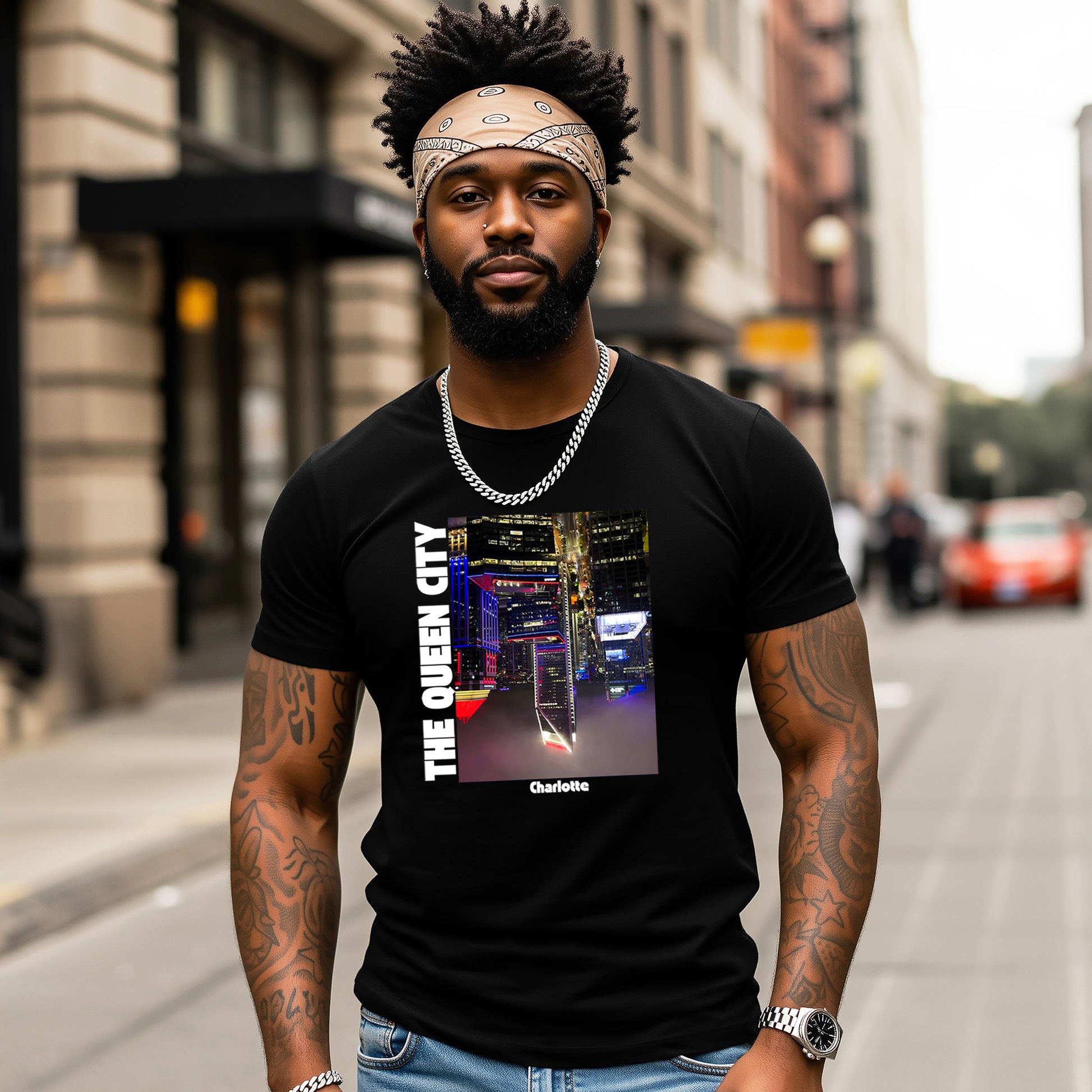 Man wearing a black t-shirt with 'The Queen City' design on a city street.