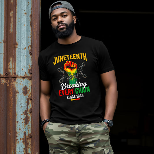 Man wearing a black t-shirt with Juneteenth design, standing against a dark background.