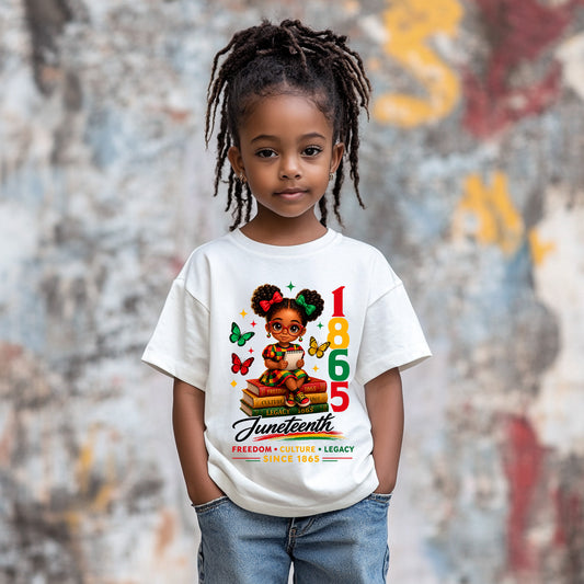 Child wearing a white t-shirt with Juneteenth design, standing against a textured wall.