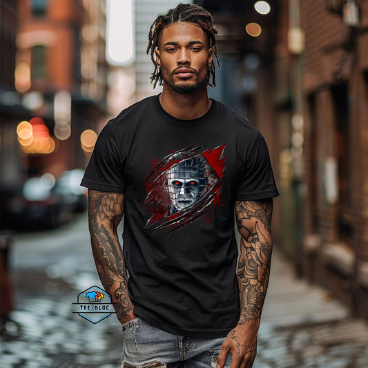 Man wearing a black t-shirt with a graphic design of a face pinhead from Hellraiser, standing on a street.