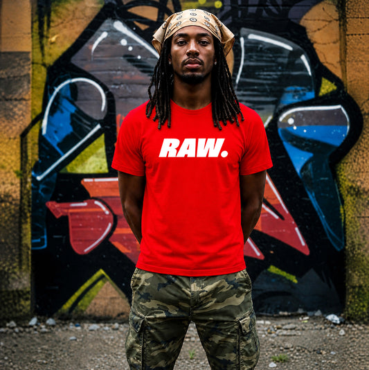 A man wearing a bright red Raw Graphic Printed & Slogan T-Shirt paired with camouflage cargo pants and a tan bandana, standing in front of a graffiti-covered wall.