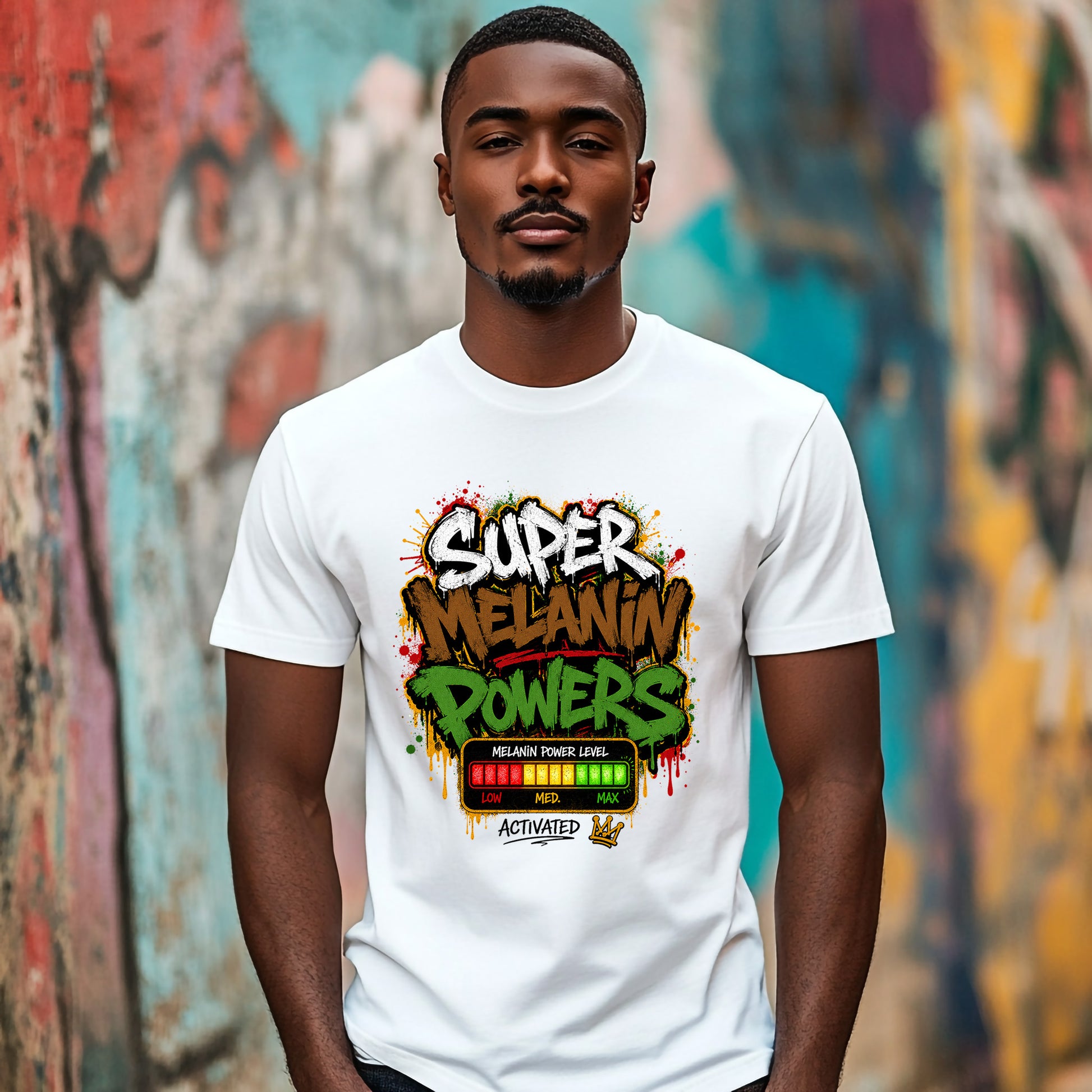 A man wearing a white graphic t-shirt with a colorful 'Super Melanin Powers' design, standing in front of a vibrant, graffiti-covered wall.